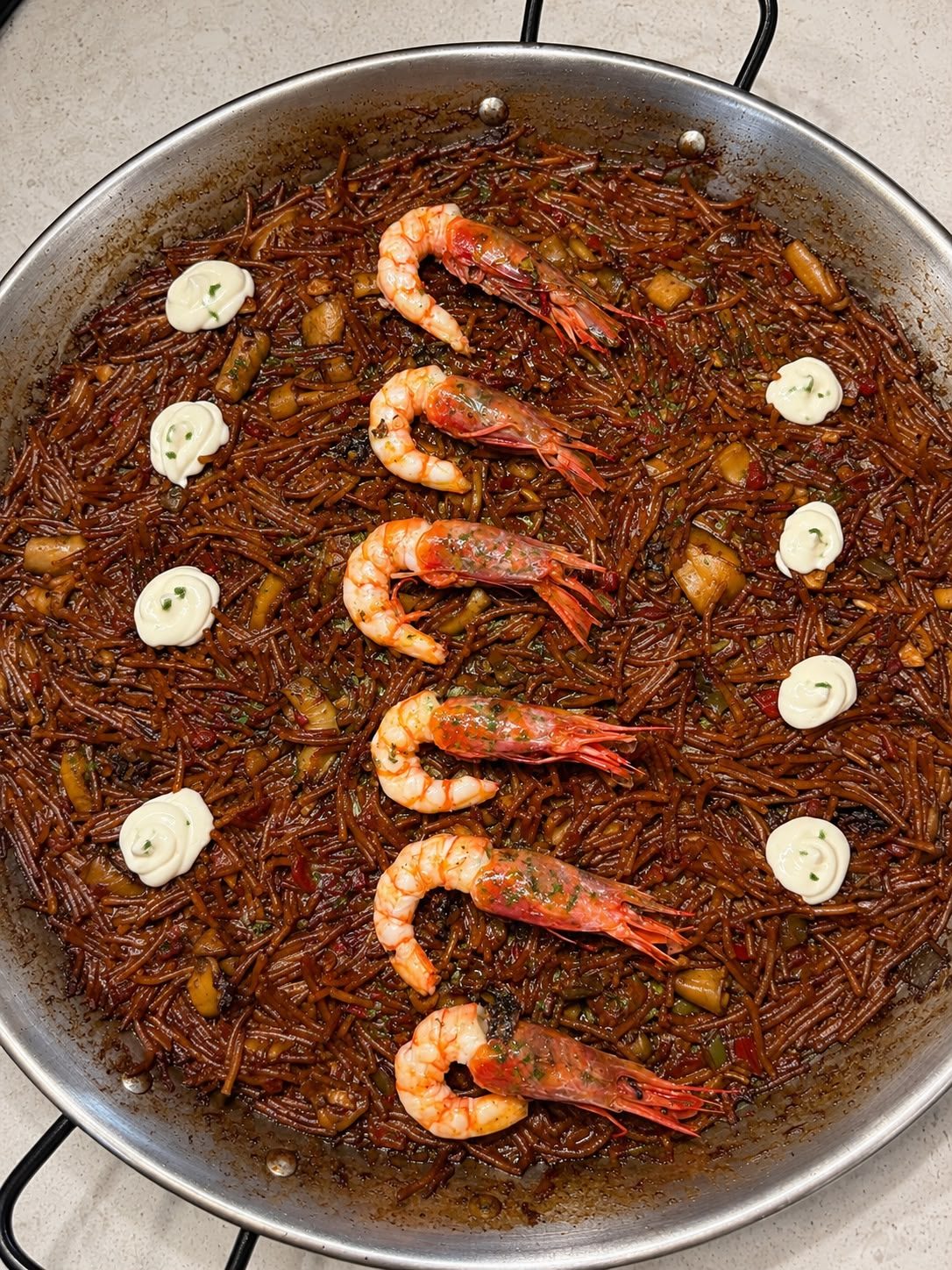 Fideos tostados con gambas y alioli, vistos desde arriba
